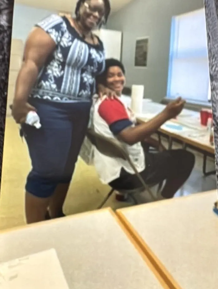 A mentor and a young participant at a program activity table